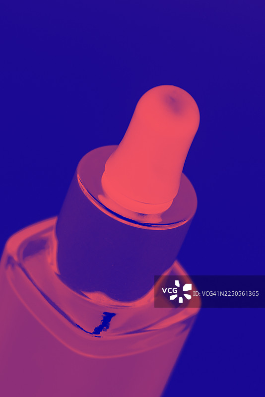 霓虹渐变滴管精华瓶，带滴头盖的玻璃瓶，适用于护肤品牌和美容实验室的产品摄影，包装展示，化妆品与科学概念图片素材