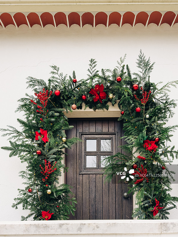 装饰着常青圣诞花环和一品红的节日前门图片素材