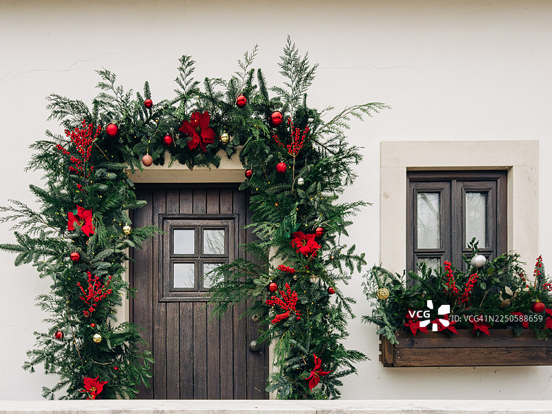 装饰着常青圣诞花环和一品红的节日正门和窗户图片素材