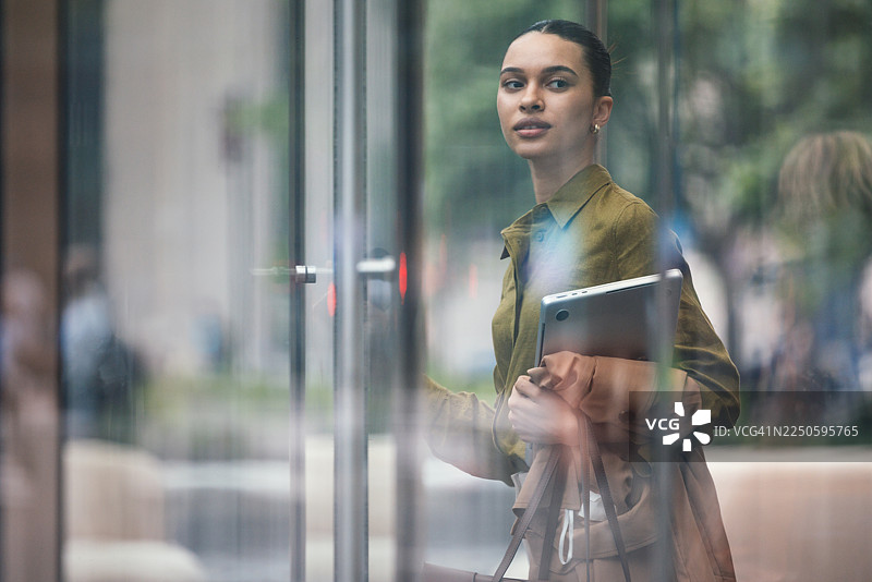 自信的女商人在平板电脑的陪伴下步入现代都市生活图片素材