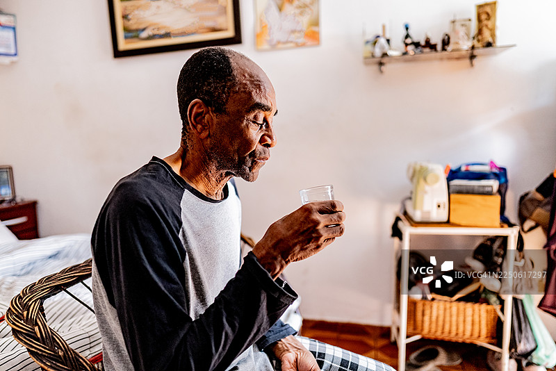 一位年长的男士在家中喝水图片素材