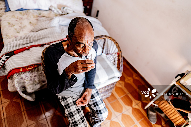 一位年长的男士在家中喝水图片素材