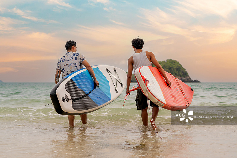 一群亚洲运动员在海上进行桨板運動，与朋友一起享受户外水上运动和泰国夏日假期的旅行。图片素材