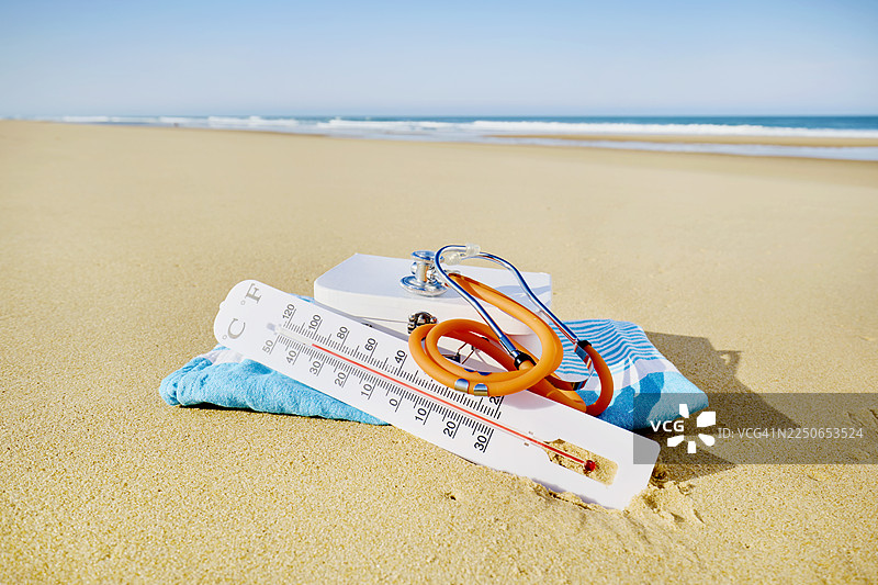 沙滩和大海上的温度计和听诊器图片素材