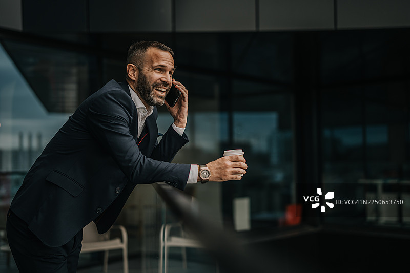 商务人士在休息时喝咖啡并打电话图片素材