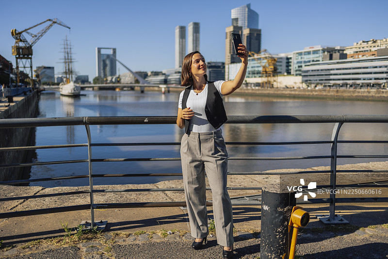 一位女士在布宜诺斯艾利斯码头用智能手机自拍图片素材