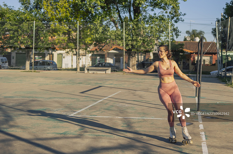 年轻女子在球场上享受轮滑的乐趣图片素材