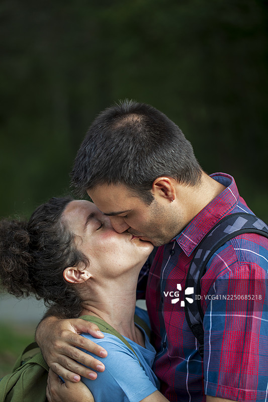 一对情侣在森林小径上深情拥抱图片素材