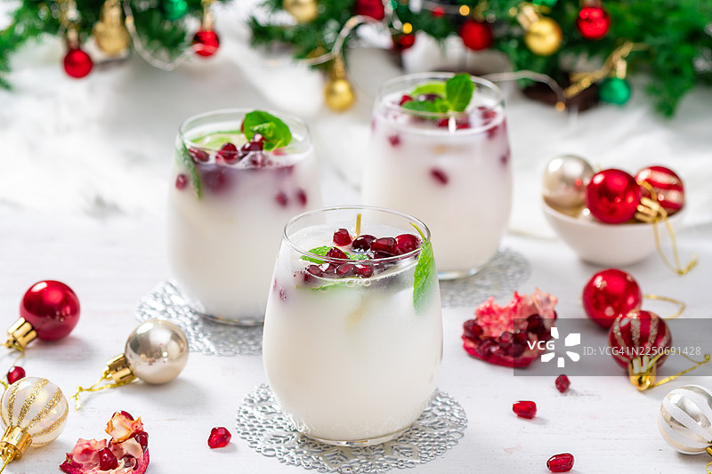 用甜酒、龙舌兰酒、椰奶、石榴籽、蔓越莓、椰蓉和清爽的薄荷制作的白色圣诞莫吉托。图片素材
