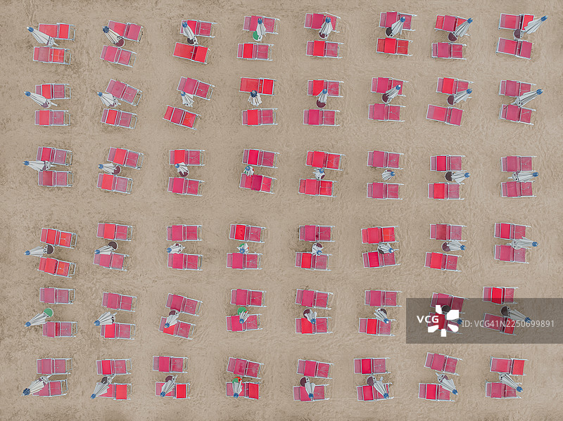 从无人机视角拍摄的成排红色沙滩椅和折叠的雨伞，阿尔巴尼亚地拉那州杜勒斯图片素材