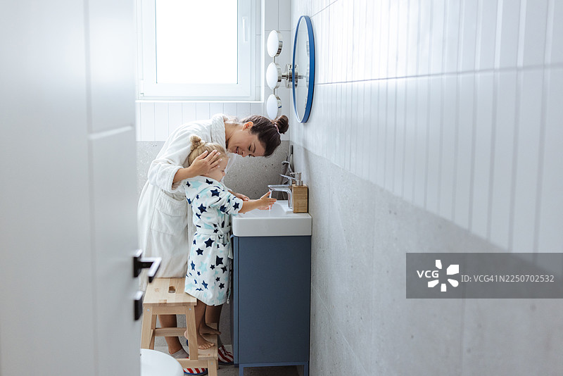 妈妈和幼儿在浴室洗手，在家中分享充满爱的卫生习惯图片素材