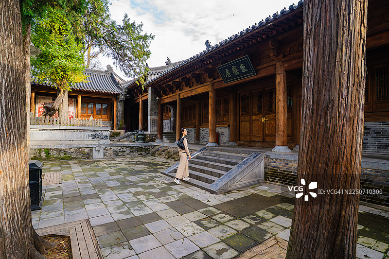 女子走过中国古代寺庙庭院图片素材