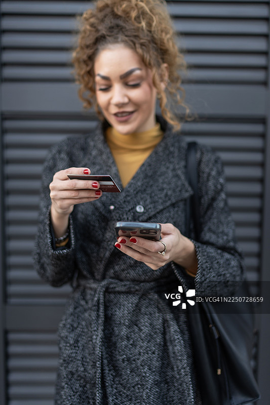 女子用信用卡和手机进行在线支付图片素材