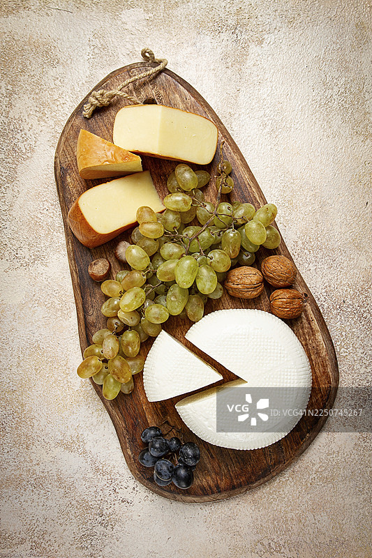 格鲁吉亚奶酪，伊梅列季奶酪和烟熏苏鲁古尼奶酪，葡萄，坚果，放在砧板上，格鲁吉亚美食，无人图片素材
