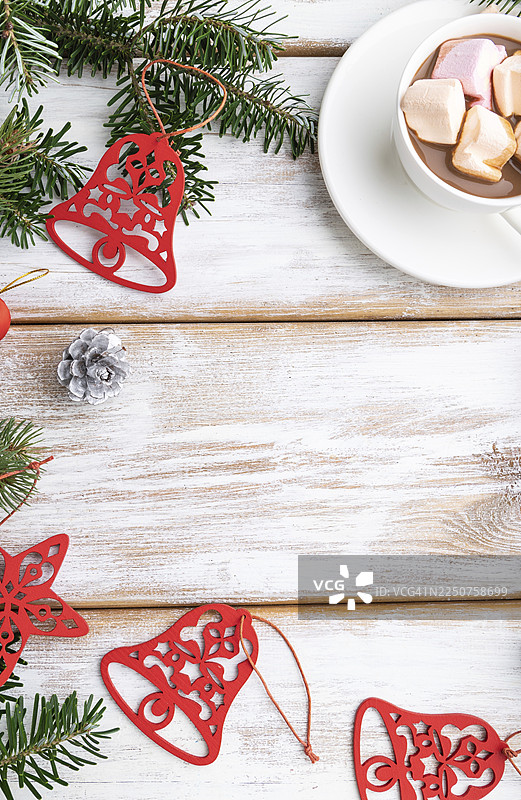 圣诞节或新年装饰画框。装饰品、红星、铃铛、松果、杉树和云杉枝、一杯咖啡，置于白色木质背景上。俯视角度，留有复制空间，平面布置图图片素材
