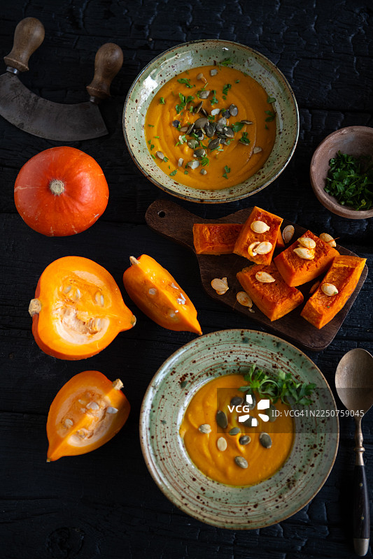 南瓜奶油浓汤搭配新鲜食材，置于深色乡村风背景上图片素材