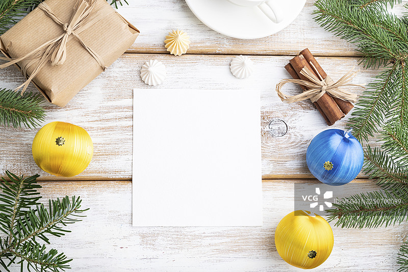 圣诞节或新年主题画框构图，模板。装饰品、盒子、彩球、肉桂、丝带、冷杉和云杉枝、咖啡杯，置于白色木质背景上。俯视角度，留有复制空间，平面布置图图片素材