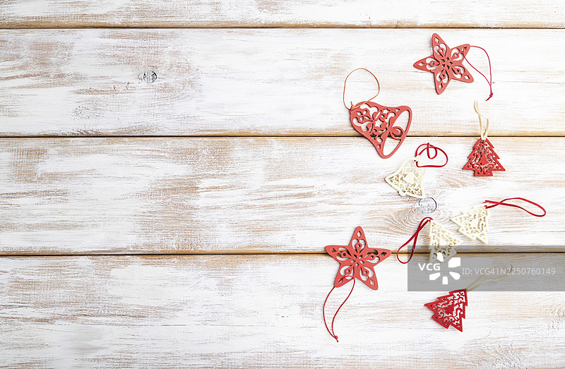 圣诞节或新年构图。白色木质背景上的装饰品、红星、铃铛。俯视，留白，平面布置图片素材