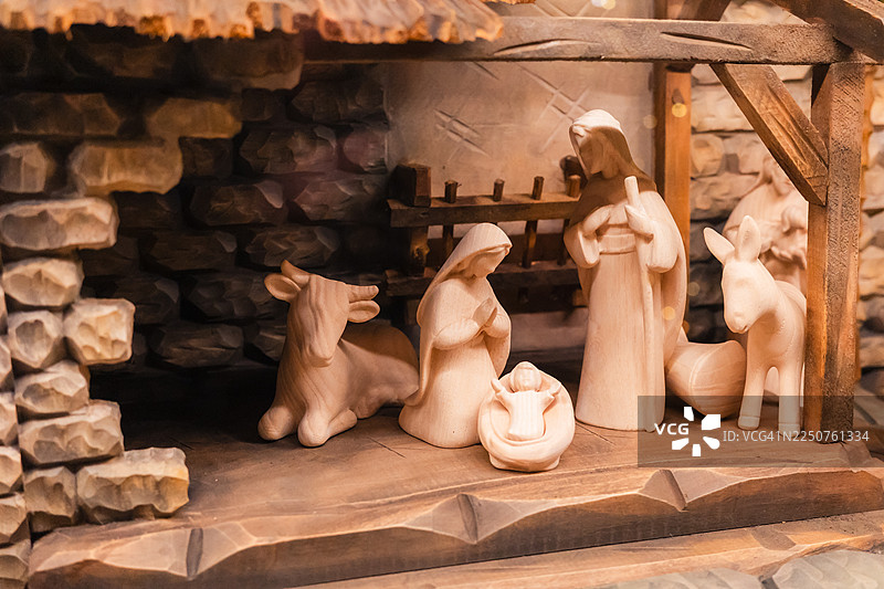 木制耶稣诞生场景，有圣婴耶稣、玛利亚、约瑟夫、动物，在乡村风格的马厩屋顶下图片素材