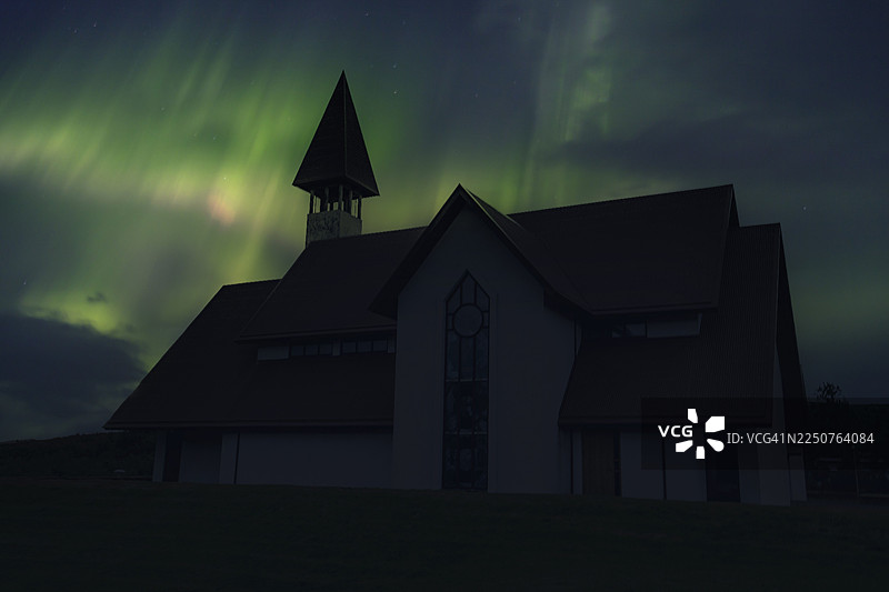 冰岛雷克雅未克市附近一座美丽的传统教堂，夜晚，伴有美丽的北极光。图片素材