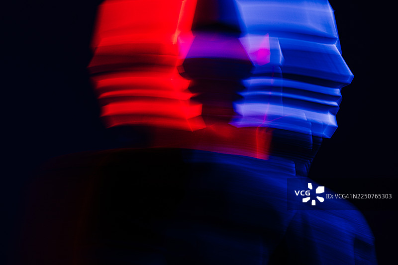 一张长曝光人像照，画面中人物佩戴几何面具，背景是鲜艳的红蓝色光轨。这张抽象构图象征着数字身份、元宇宙以及在高科技世界中自我的流动性。图片素材