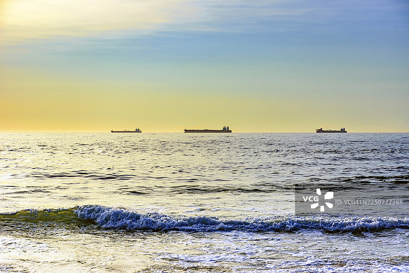 黎明时分，船只停泊在伊帕内玛海滩的地平线上，等待入港图片素材