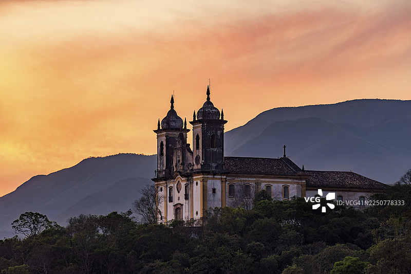 巴西米纳斯吉拉斯州欧鲁普雷图市山上巴洛克风格的历史教堂，日落时分图片素材