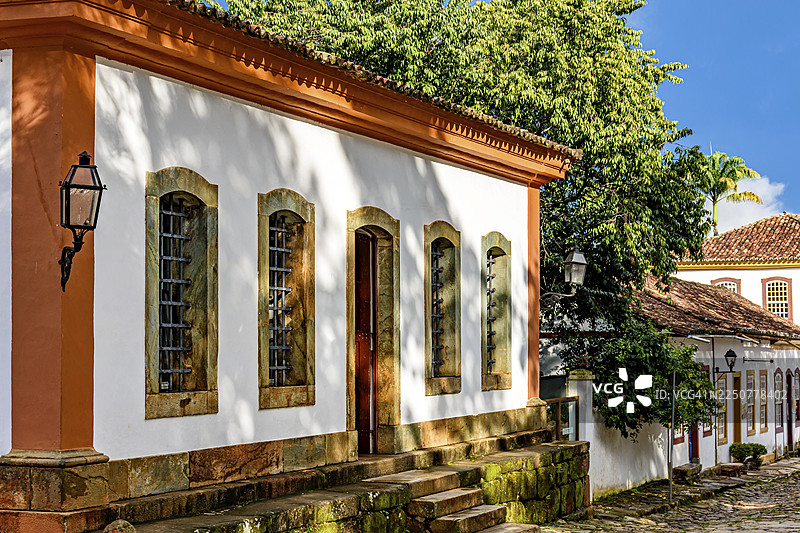 巴西米纳斯吉拉斯州历史名城蒂拉登特斯鹅卵石街道上，古老彩色殖民时期房屋的立面图片素材
