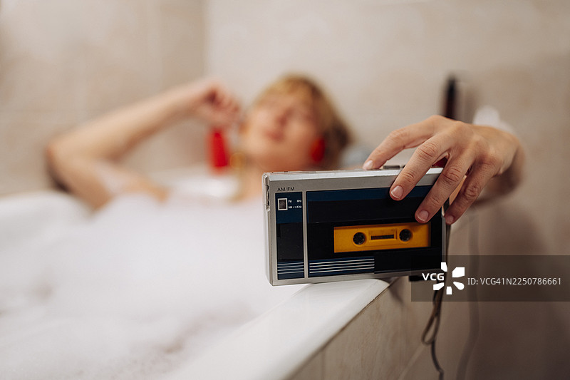 手持复古卡带播放器，享受轻松沐浴时光图片素材
