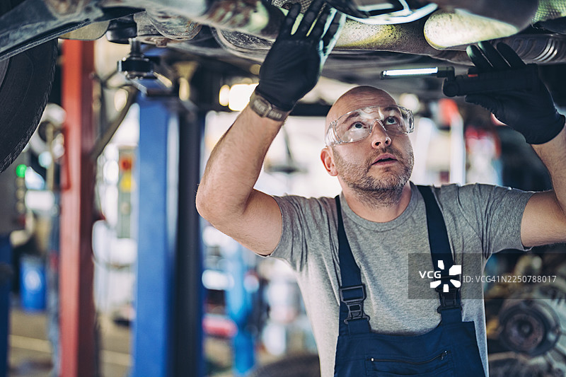 汽车修理工检查汽车底部图片素材