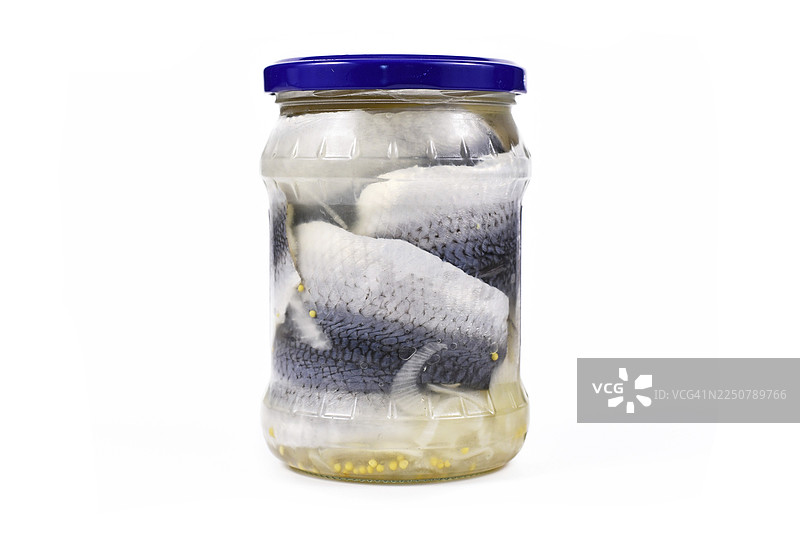 罐装的鲱鱼，配有洋葱，用蓝盖密封，并带有咸味和腌制风味，在白色背景上孤立展示。图片素材