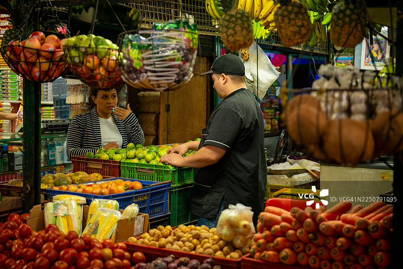 店主在麦德林市场协助顾客图片素材