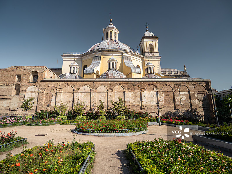 从马德里（西班牙）的公共植物园（鲜花盛开）看出去，圣弗朗西斯科大教堂（Real Basilica de San Francisco El Grande）的尖塔和圆顶的侧视图，这是一座18世纪的新古典主义建筑。图片素材