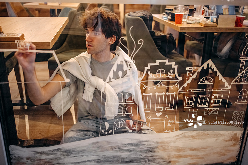 艺术家在咖啡馆的窗户上创作圣诞装饰图片素材