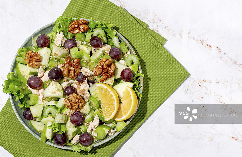 新鲜的华尔道夫沙拉，包含鸡肉、苹果和核桃的芹菜梗、葡萄、香草，自制，无人物图片素材