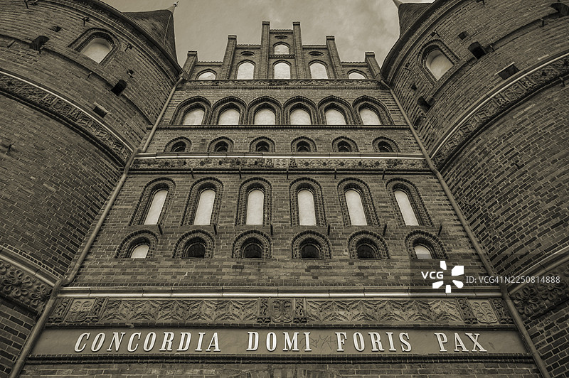 Concodia Domini Fotris Pax：主的和谐，父亲的和平，一句刻在1478年的历史悠久的霍尔斯滕门上的话，褐色，霍尔斯滕门广场，汉萨同盟城市吕贝克，石勒苏益格-荷尔斯泰因州，德国图片素材