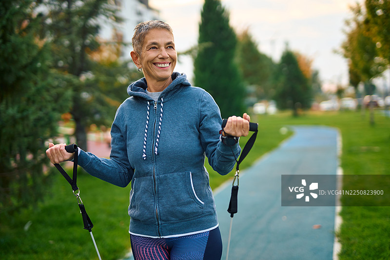 老年女性在户外使用弹力带锻炼图片素材