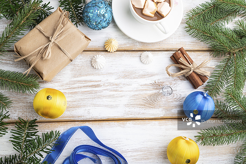 圣诞节或新年装饰画框构图。白色木质背景上的装饰品、盒子、球、肉桂、丝带、冷杉和云杉枝、咖啡杯。俯视，留白，平面布置图片素材