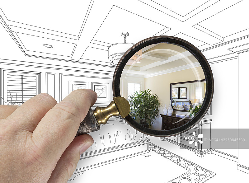 手持放大镜展示定制卧室设计图和照片的组合图片素材