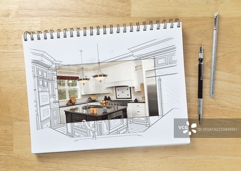 画板放在桌子上，上面画着定制厨房的草图，旁边有一个展示完工建筑的方框区域，旁边放着工程铅笔和比例尺图片素材