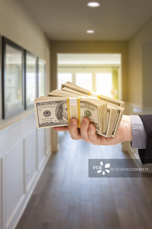 新房走廊里，一只手拿着一叠现金图片素材