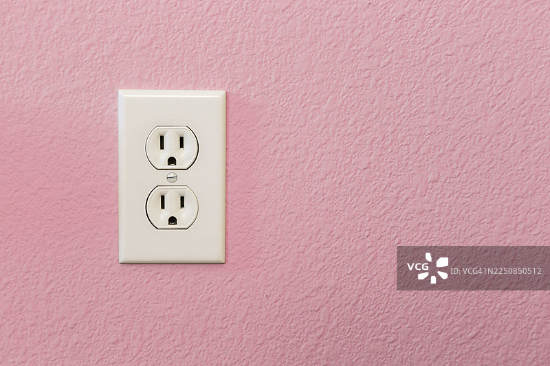 房屋粉色墙壁上的彩色电源插座图片素材