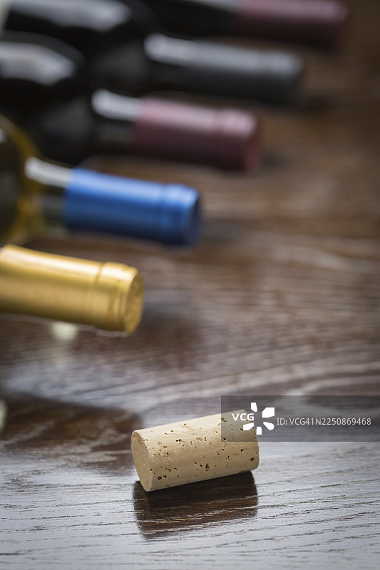 酒瓶和软木塞在反光木质表面上的抽象图案图片素材