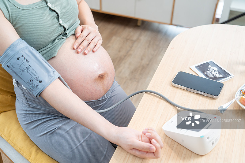 孕妇在家测量血压，孕期妈妈的健康检查图片素材