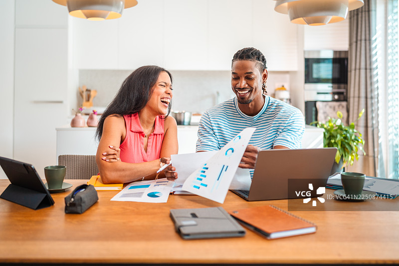 中年夫妇愉快地使用笔记本电脑分享家庭预算信息图片素材