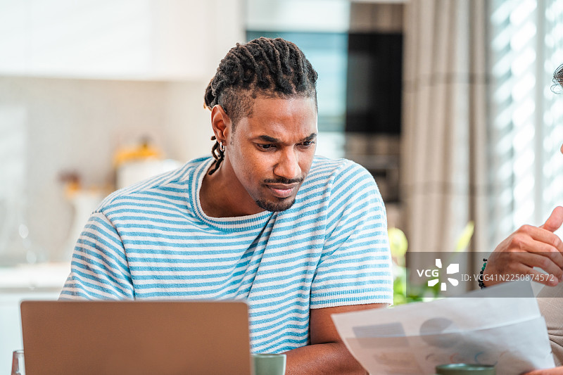中年黑人男性全神贯注地审阅财务文件图片素材