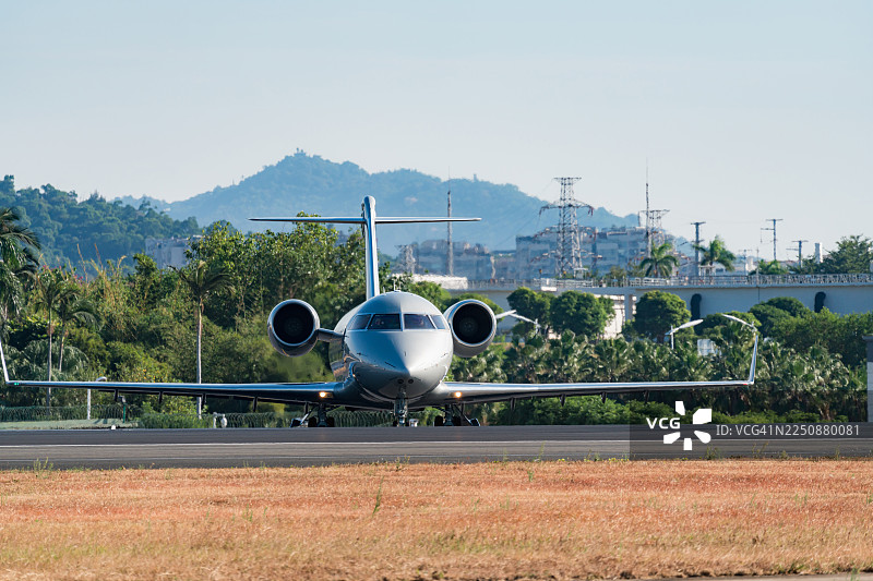 一架商务喷气机正在跑道上滑行，准备起飞。图片素材