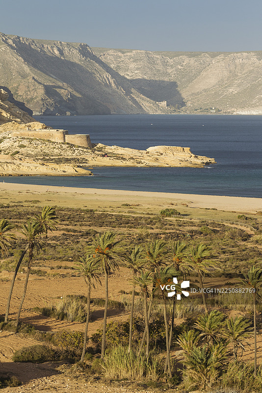 位于西班牙安达卢西亚阿尔梅里亚省卡沃德加塔-尼哈尔自然保护区的Playazo海滩，左侧有棕榈树和圣雷蒙城堡图片素材