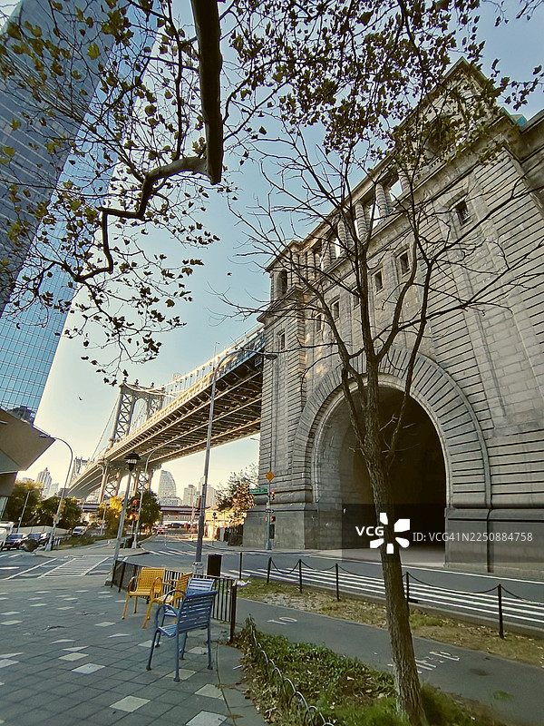 秋季时节，从布鲁克林区邓波（DUMBO）街区眺望曼哈顿大桥及其石拱门，美国纽约市图片素材