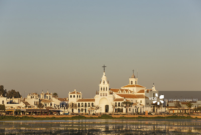 西班牙韦尔瓦省安达卢西亚地区，多尼亚纳国家公园内，埃尔罗西奥村，坐落在埃尔罗西奥沼泽（马德雷沼泽）旁的埃尔罗西奥隐修院。图片素材